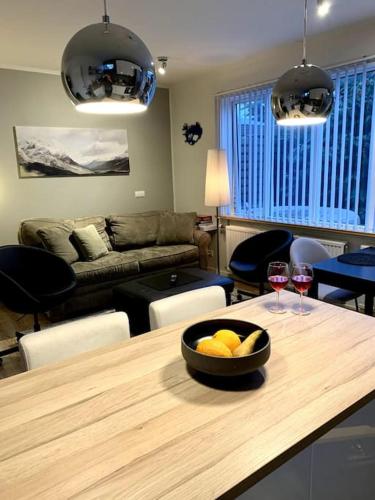 a living room with a table with a bowl of fruit and wine glasses at Cosy one bedroom apartment in Reykjavík in Reykjavík