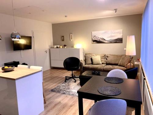 uma sala de estar com um sofá, uma mesa e cadeiras em Cosy one bedroom apartment in Reykjavík em Reykjavík