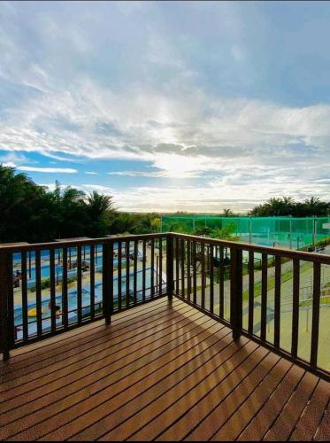 a wooden deck with a view of a body of water at Apt próximo à praia de Ponta Negra/Litoral Sul/Natal in Parnamirim