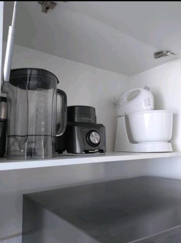 a kitchen shelf with a blender and other appliances at Apt próximo à praia de Ponta Negra/Litoral Sul/Natal in Parnamirim