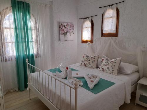 - une chambre dotée d'un lit blanc avec deux poupées dans l'établissement Stella Apartments Malia, à Mália
