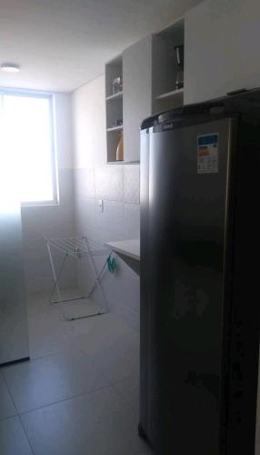 a kitchen with a black refrigerator in a room at Apt próximo à praia de Ponta Negra/Litoral Sul/Natal in Parnamirim