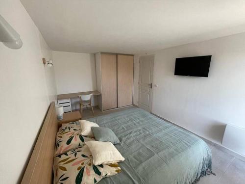 ein Schlafzimmer mit einem großen Bett und einem Flachbild-TV in der Unterkunft Appartement neuf avec jacuzzi privatif et piscine in Seillans