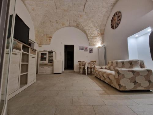 ein Wohnzimmer mit einem Sofa, einem TV und einem Tisch in der Unterkunft Casa Dolce Vita in Carovigno