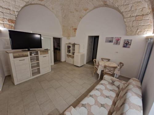 ein Wohnzimmer mit einem TV und einem Tisch in der Unterkunft Casa Dolce Vita in Carovigno