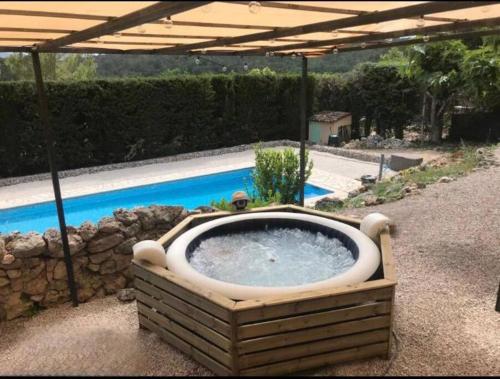 eine große Badewanne im Hof mit Pool in der Unterkunft Appartement neuf avec jacuzzi privatif et piscine in Seillans