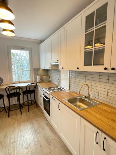 a kitchen with white cabinets and a sink at Zatoka spokoju in Gdynia