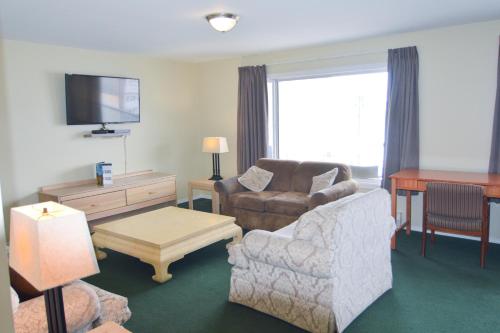 uma sala de estar com um sofá e uma cadeira em Shoreline Resort Condominiums em Penticton