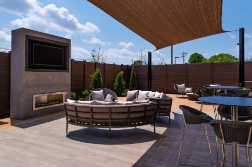 a patio with a couch and a tv and a fireplace at Courtyard by Marriott Charlotte Northlake in Charlotte