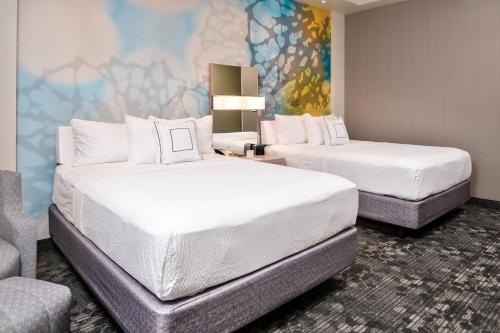 a hotel room with two beds and a couch at Courtyard by Marriott Charlotte Northlake in Charlotte