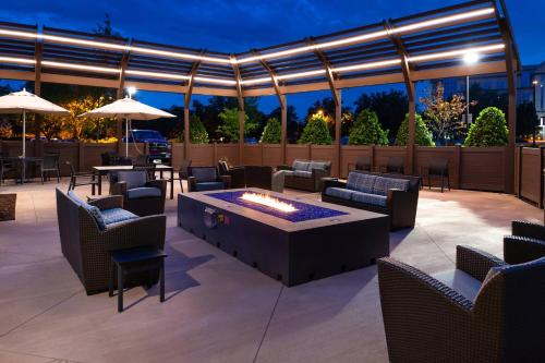 a patio with a fire pit and tables and chairs at Courtyard by Marriott Charlotte Northlake in Charlotte