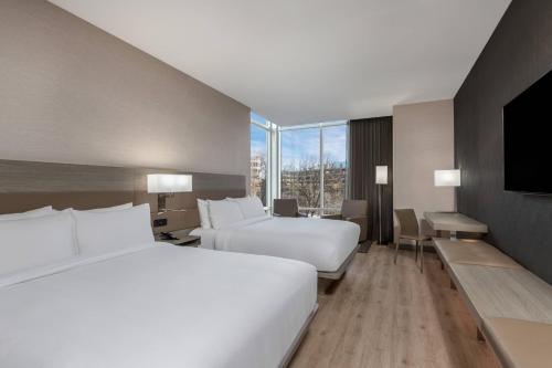 AC Hotel by Marriott Atlanta Midtown في أتلانتا: غرفه فندقيه سريرين وتلفزيون