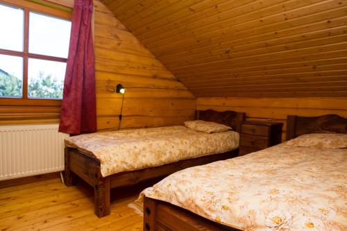a bedroom with two beds in a log cabin at Askari puhkemaja in Räni