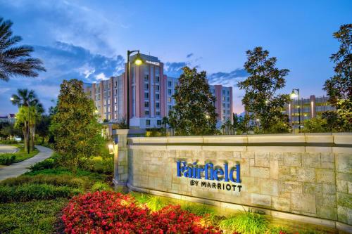 un bâtiment avec un panneau en face d'un parc dans l'établissement Fairfield by Marriott Inn & Suites Orlando at FLAMINGO CROSSINGS® Town Center, à Orlando