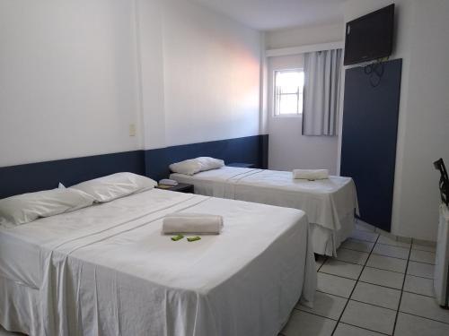 a room with two beds and a tv in it at One Hotel in João Pessoa
