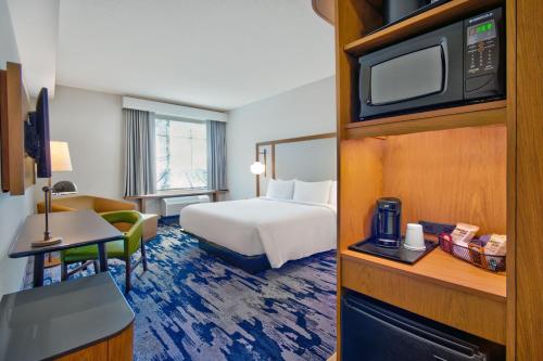 a hotel room with a bed and a tv at Fairfield by Marriott Inn & Suites Orlando at FLAMINGO CROSSINGS® Town Center in Orlando
