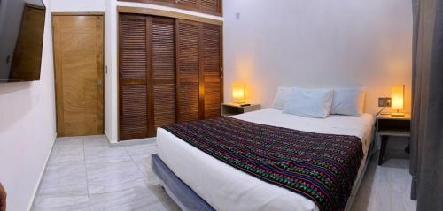 a bedroom with a bed and a desk with two lamps at Palmas de Chahue in Santa Cruz Huatulco
