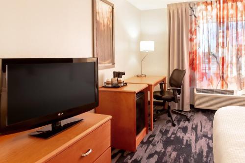 a hotel room with a flat screen tv and a desk at Fairfield Inn & Suites Minneapolis Eden Prairie in Eden Prairie