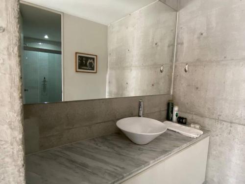 a bathroom with a bowl sink and a mirror at Super cool & comfortable in the heart of Condesa. in Mexico City