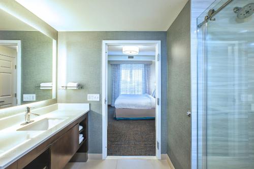 baño con lavabo y ducha con cama en Residence Inn Rochester Henrietta, en Rochester