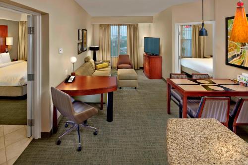 レイクメアリーにあるResidence Inn Orlando Lake Maryのデスクとリビングルームが備わるホテルルームです。