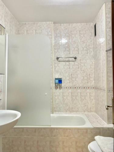 a bathroom with a shower with a tub and a sink at Lemos Estrella in Monforte de Lemos