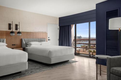 a hotel room with two beds and a balcony at Marina del Rey Marriott in Los Angeles