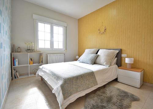 um quarto com uma cama e uma parede amarela em Enoturismo Casa de Chantada em Meis