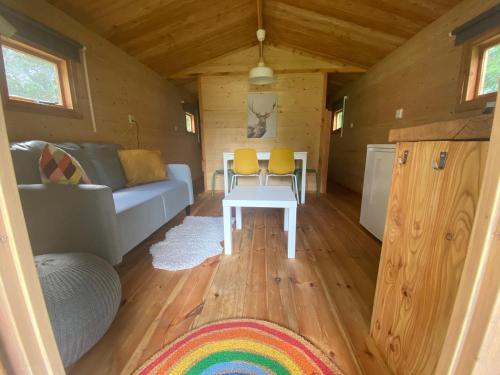 a living room of a tiny house with a couch and a table at Blokhut 4-persoons De Blauwe Lantaarn in Wateren