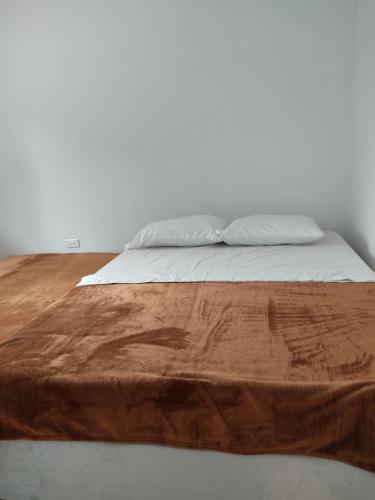 a close up of a bed with a wooden head board at Habitación en apartahotel Sarita Salento in Salento