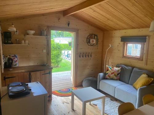a living room with a couch and a table at Blokhut 4-persoons De Blauwe Lantaarn in Wateren