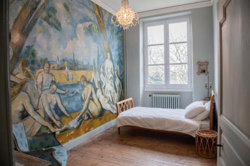 une chambre avec un grand tableau sur le mur dans l'établissement Les Charmilles, à Sames