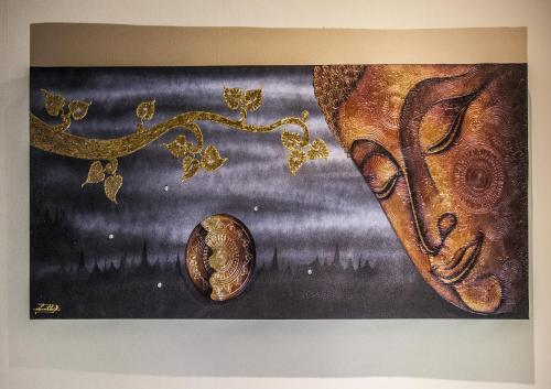 a painting of a face and a coin on a wall at Boardinghouse Remchingen Baan Arun in Remchingen