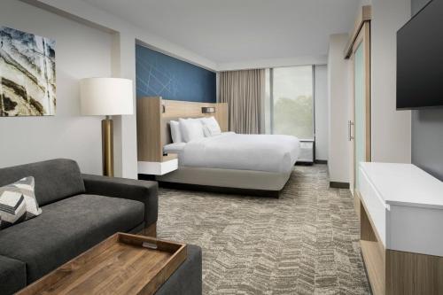 a hotel room with a bed and a couch at SpringHill Suites by Marriott Atlanta Perimeter Center in Atlanta