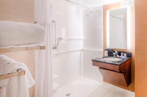 a white bathroom with a shower and a sink at Fairfield Inn & Suites by Marriott Winston-Salem Downtown in Winston-Salem