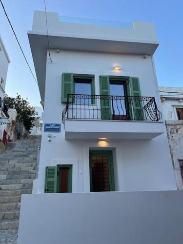 La Casa Verde في إرموبولّي: مبنى أبيض بنوافذ خضراء وشرفة