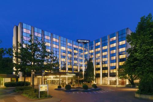 un grand bâtiment avec un panneau sur son côté dans l'établissement Sheraton Essen Hotel, à Essen