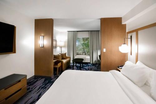 Cette chambre comprend un grand lit et un canapé. dans l'établissement Fairfield by Marriott Inn & Suites Louisville Airport, à Louisville