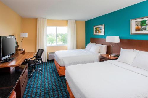 a hotel room with two beds and a flat screen tv at Fairfield Inn & Suites South Bend Mishawaka in South Bend