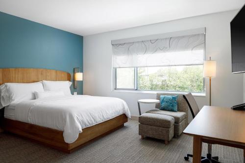 a bedroom with a bed and a chair and a window at Element Nashville Airport in Nashville