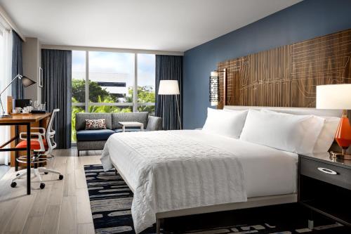 Habitación de hotel con cama grande y escritorio. en Le Méridien Dania Beach at Fort Lauderdale Airport, en Avon Park