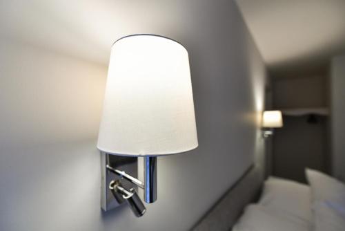 a lamp on a wall in a hotel room at Rooms at Rolleston in Rolleston
