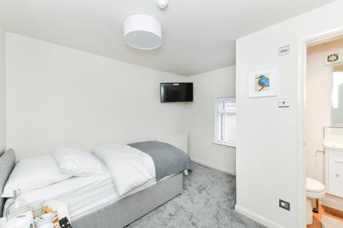 a small bedroom with a bed and a tv at Rooms at Rolleston in Rolleston