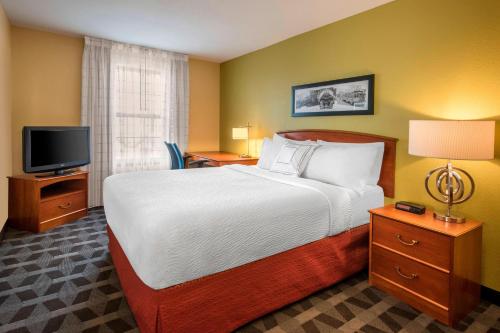 a hotel room with a bed and a television at TownePlace Suites Denver Tech Center in Centennial
