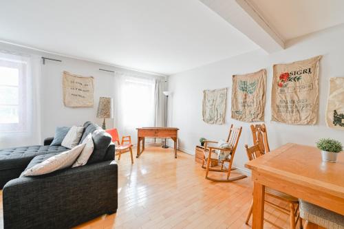 sala de estar con sofá y mesa en L'Auberge du QG, en Laprairie