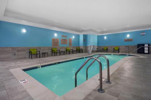 a pool in a hotel room with chairs and tables at SpringHill Suites by Marriott Hartford Cromwell in Cromwell