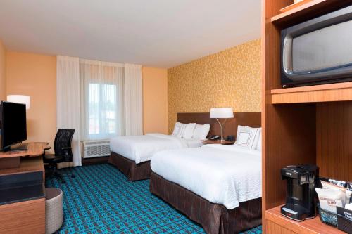 a hotel room with two beds and a flat screen tv at Fairfield Inn & Suites by Marriott West Monroe in West Monroe