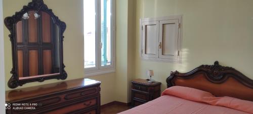 Schlafzimmer mit einem Bett, einer Kommode und einem Spiegel in der Unterkunft ViaRoma60_CasaVacanze in Ospedaletti