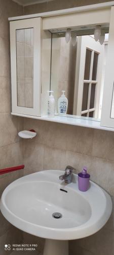ein Badezimmer mit einem weißen Waschbecken und einem Spiegel in der Unterkunft ViaRoma60_CasaVacanze in Ospedaletti