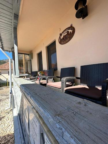 a patio with wicker chairs and tables on a building at Casa bunicilor din Leresti in Voineşti